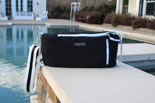 Black bag with white accents on a ledge by a pool
